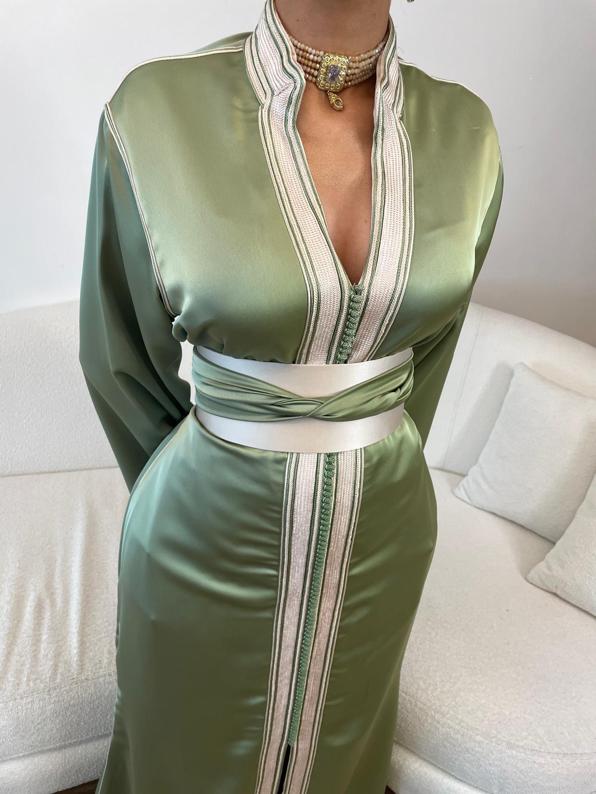 Femme portant un caftan sauge en satin avec bijoux dorés

